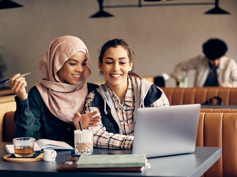 Two female students working on a laptop